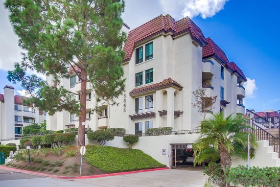 Front view of a multi-story building with red-tiled roof and balconies.