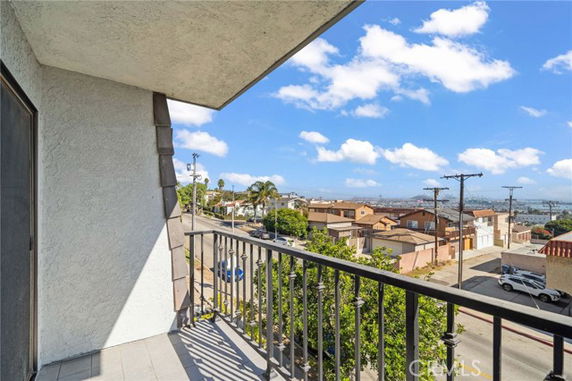 Balcony view overlooking a residential area and distant cityscape.