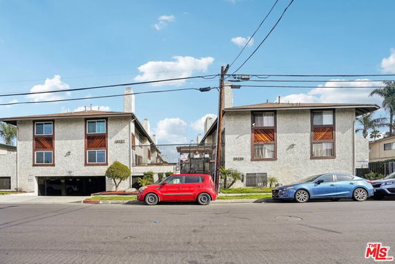 Front view of a two-story apartment building with parking on the ground floor.