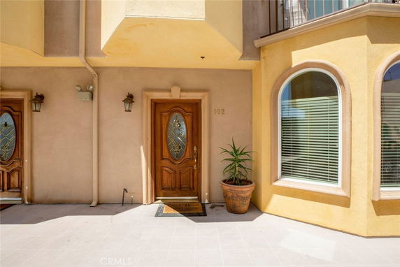Front view of a house with a wooden door and decorative sidelights.