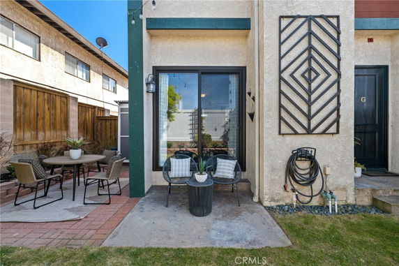 Front view of a house with a small patio area and decorative wall art.