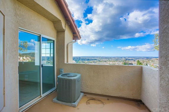 Balcony view overlooking a landscape with sky and clouds.