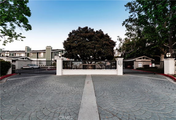 Front view of a multi-story residential building with a gated entrance.