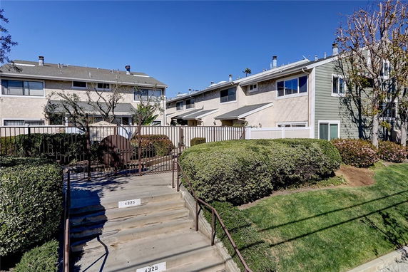 Front view of a row of two-story townhouses with a gated entrance.