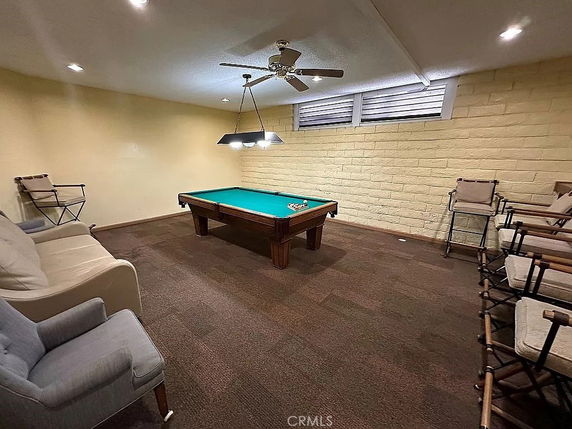 Room with a pool table and seating area.