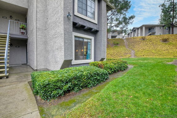 Front view of an apartment building with ground floor entry and large windows.