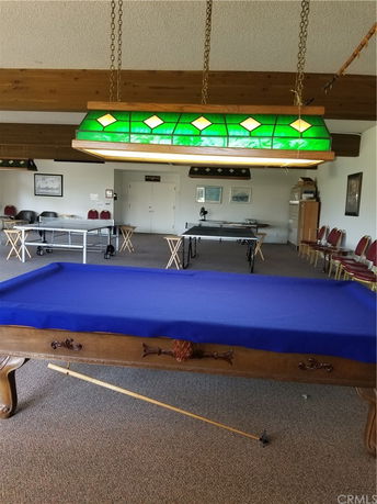 Interior view of a clubhouse with a billiards table and seating area.