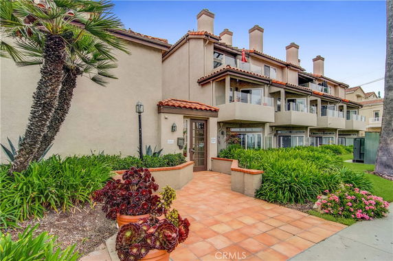 Front view of a multi-story residential building with balconies and a tiled entrance.