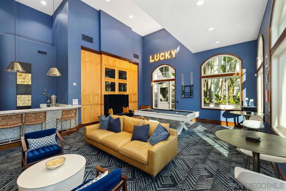 Recreational indoor area with pool table, seating, and bar counter.