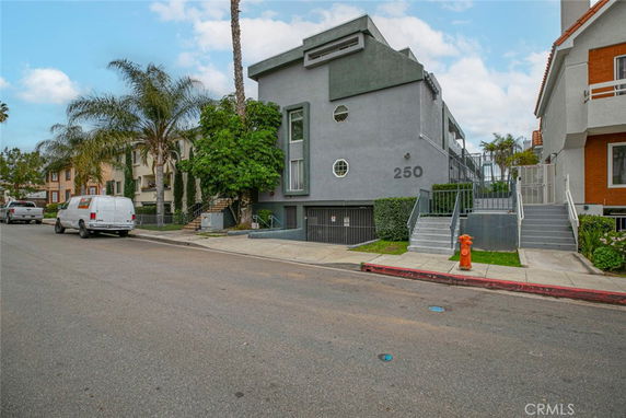 Front view of a gray multi-story building with steps leading to the entrance.