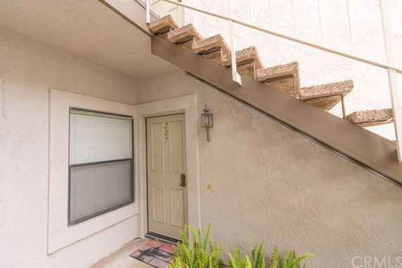 Front view of a residential entryway under a staircase.