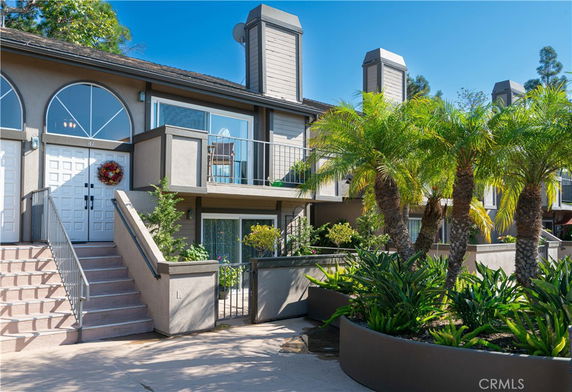 Front view of a two-story residential building with arched windows and a central staircase.