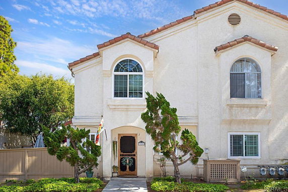 Front view of a two-story house with arched windows and a tiled roof.
