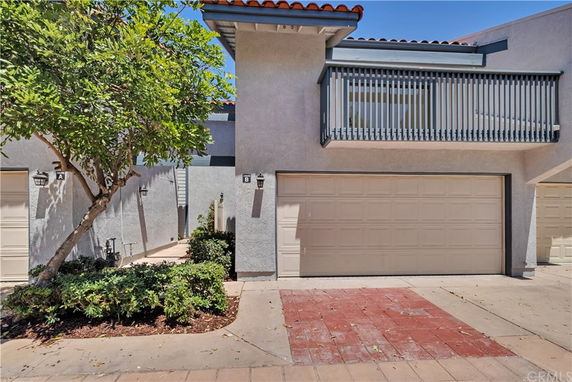 Front view of a two-story house with a balcony and double garage.