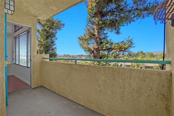 Building balcony with a view of trees and distant landscape.