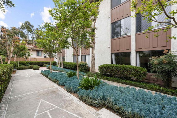 Front view of a multi-story building with landscaped pathway.