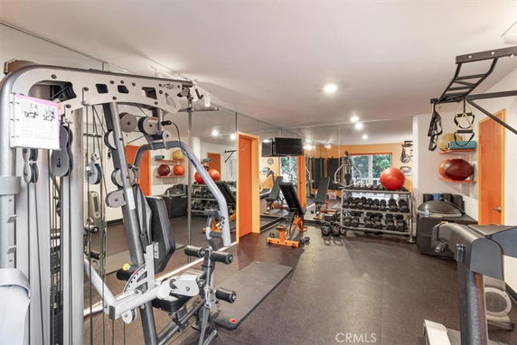 Indoor fitness area with gym equipment and mirrors.