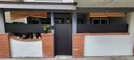 Front view of a house entrance with a gated porch and brick details.