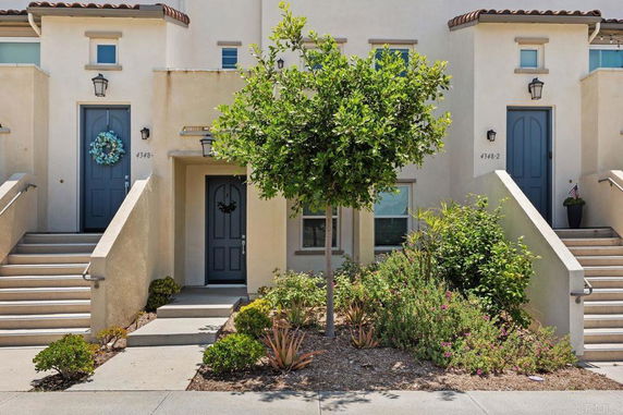 Front view of a multi-unit residential building with stairs leading to individual entrances.