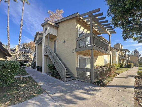 Front view of a two-story building with balconies and stairs.