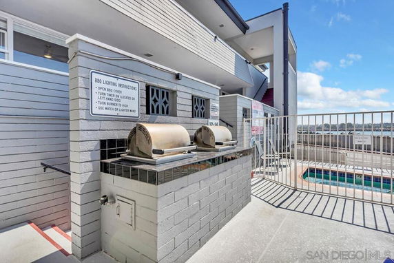 Outdoor area with a BBQ setup and a fenced swimming pool.