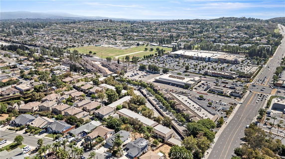 Aerial panoramic view of a suburban area with houses, roads, and surrounding landscape.
