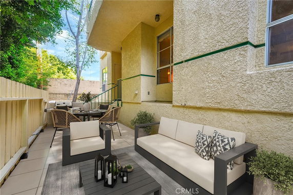 Outdoor patio area with seating and dining furniture adjacent to a building.