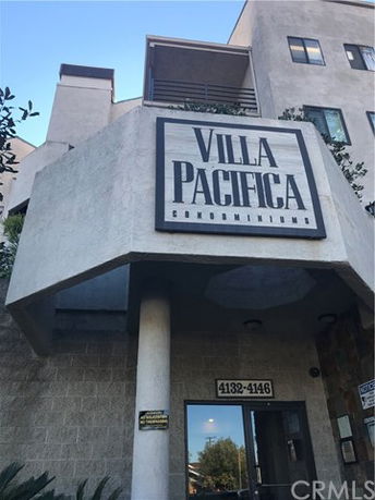 Front view of a condominium building with a sign reading 'Villa Pacifica.'