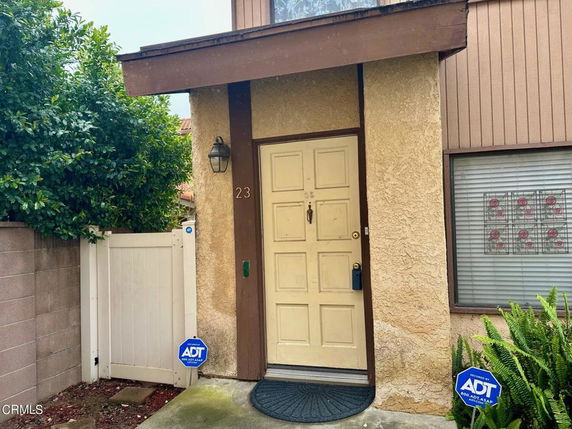 Front view of a house entrance with a single door and a window beside it.