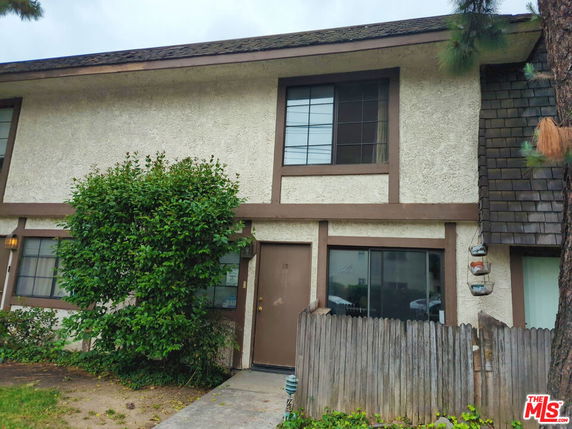 Front view of a two-story house with a main door and windows on both floors.
