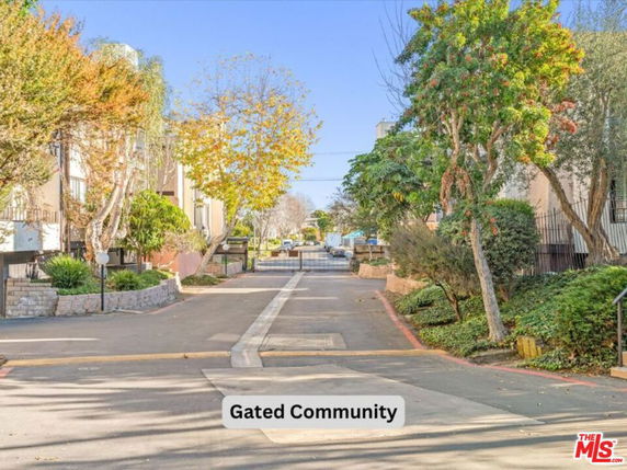 Front view of a gated community entrance with surrounding trees.