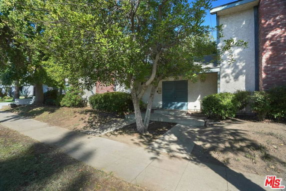 Front view of a house with a concrete path leading to the entrance.
