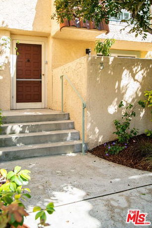 Front view of a building entrance with stairs leading to a door.