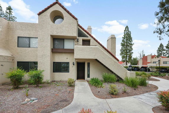 Front view of a modern two-story house with a sloped roof and external staircase.