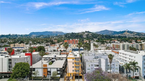 Panoramic view of urban buildings with mountains in the background.