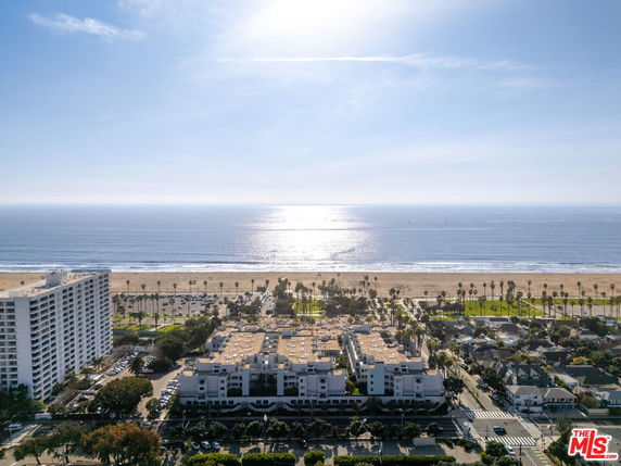 Panoramic view of buildings near a beach with ocean in the background.