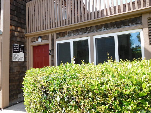 Front view of a building with wooden exterior and red door.