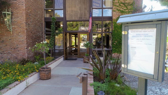 Entrance view of a building with a glass doorway and brick walls.