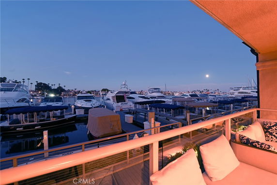 View from a terrace overlooking a marina with several boats during twilight.