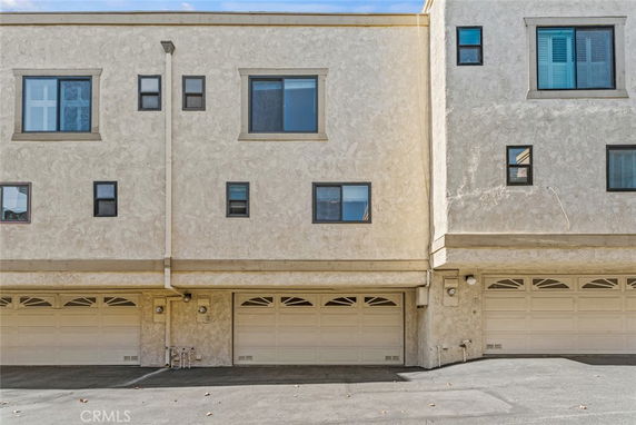 Front view of a multi-story building with garages on the ground floor.