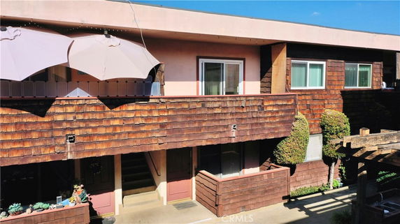 Front view of a two-story building with wooden siding and balconies.