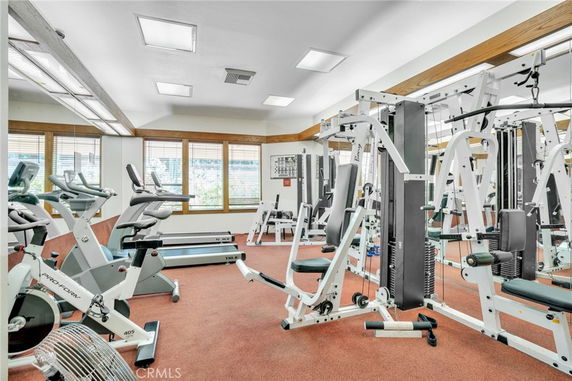 Indoor gym area with exercise equipment including stationary bikes, treadmills, and weight machines.