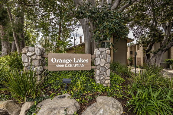 Front view of the Orange Lakes building entrance with a sign and stone pillars.
