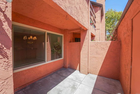 Exterior of a building with orange textured walls and large windows.