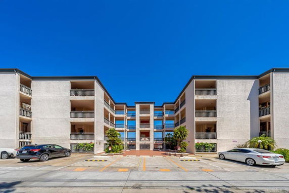 Front view of a multi-story apartment building with balconies.