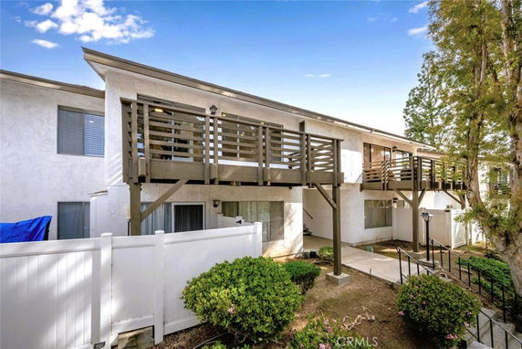 Front view of a two-story building with balconies and white exterior walls.