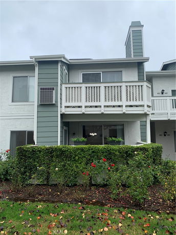 Front view of a two-story house with a balcony and chimney.
