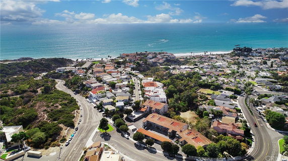 Aerial view of a coastal neighborhood with roads and buildings near the ocean.