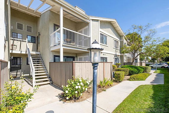 Front view of a two-story residential building with balconies and staircases.