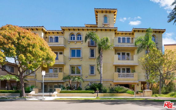 Front view of a four-story apartment building with balconies.